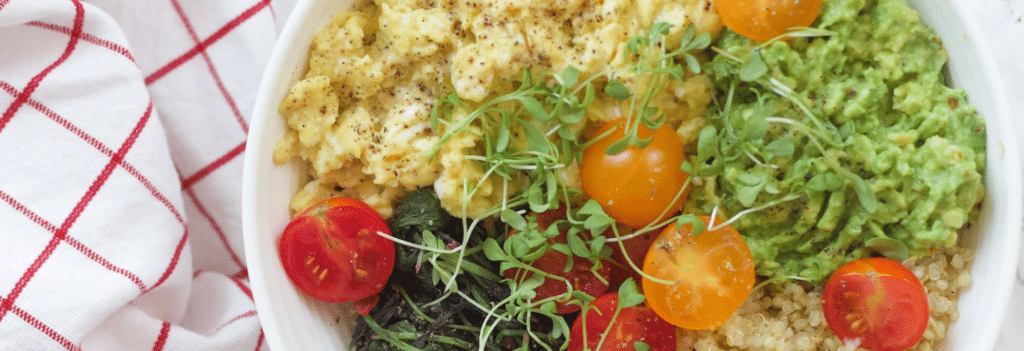 Bowl with eggs, tomatoes, quinoa and microgreens