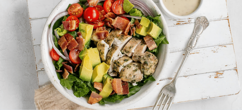 A white bowl of chicken and bacon ranch salad